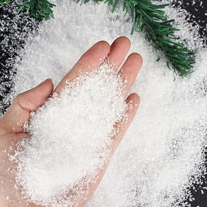 Artificial snow powder for Christmas decor showing fluffy texture with pine branches