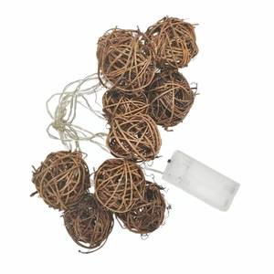 Detailed view of woven rattan ball LED string lights with a transparent wire and battery box