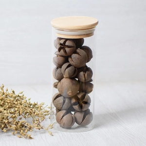 Natural dried cross fruits in a glass storage jar with a wooden lid for DIY crafts