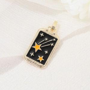 Macro detail of gold-plated The Star tarot pendant with black enamel finish