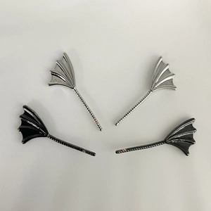 Détail de breloques en forme d'ailes de démon argentées et noires pour bijoux faits à la main