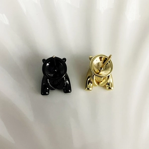 Détail de fermoirs de boucles d'oreilles ours en émail doré et noir avec tige métallique