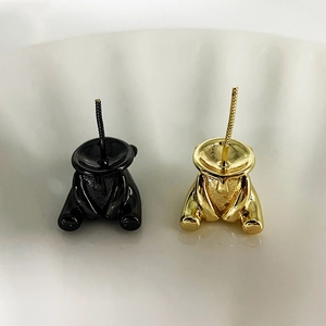 Détail de boucles d'oreilles ours montrant la soudure et les finitions dorée et noire