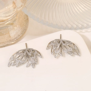 Eleganti orecchini a piuma in argento con zirconi scintillanti su vassoio di ceramica