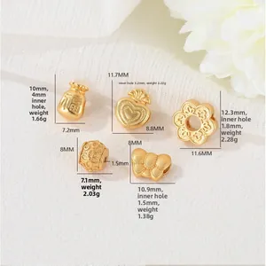 Macro detail of gold charms with lucky bag and heart patterns for DIY jewelry making