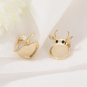 Golden apple and bull head zircon pins displayed on soft white fabric background