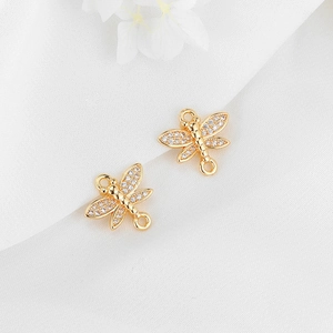 Detalle macro del colgante de libélula chapado en oro 14K con circonitas y doble anilla de unión