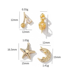 Macro detail of 14k gold-plated star, moon, and crown charms for DIY jewelry making