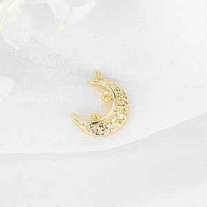 Detailed macro view of a golden crescent moon pendant with star patterns for DIY jewelry