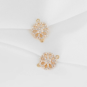 Macro detail of gold flower connectors with pave-set cubic zirconia for jewelry making