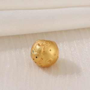 Detailed macro of golden matte spacer bead with blue enamel star and astronaut pattern