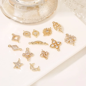 Detailed view of assorted 18K gold plated clover and star charms with pavé cubic zirconia