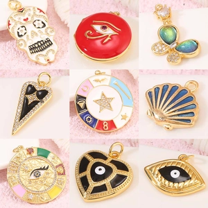 Detalle de varios dijes chapados en oro con circonitas y motivos de mariposas y estrellas