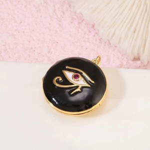 Detalle macro del relicario redondo de esmalte negro con ojo de Horus y circón rosa fino