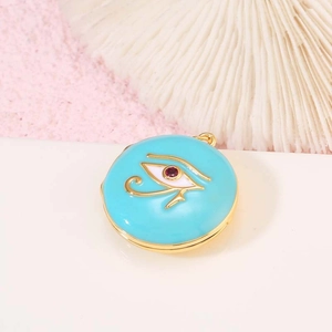 Primer plano del relicario dorado con esmalte azul y motivo del ojo de Horus