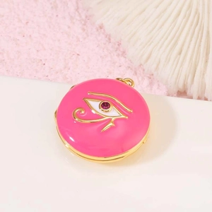Detalle macro del relicario de esmalte rosa Ojo de Horus con baño de oro y circón