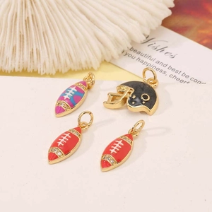 Macro shot of 14K gold-plated football and helmet pendants with colorful enamel coating
