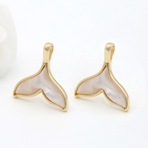 Macro detail of 14k gold-plated whale tail pendants with natural mother-of-pearl inlay