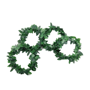 Detail of four artificial green leaf napkin rings showing realistic textures and veins