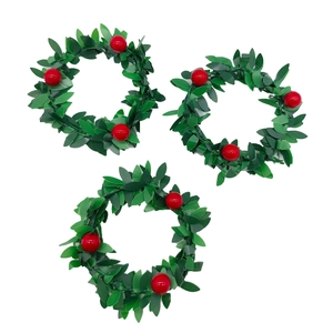 Detail of three green Christmas napkin rings with red berries on white background