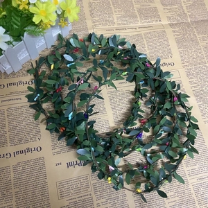 Gros plan d'une couronne de cheveux de style forêt avec feuilles vertes et bourgeons colorés
