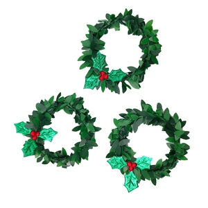 Detail of three green Christmas napkin rings with red berries and glittery holly leaves