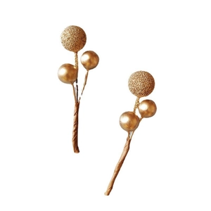 Detail view of two gold Christmas berry branches with textured and smooth spheres