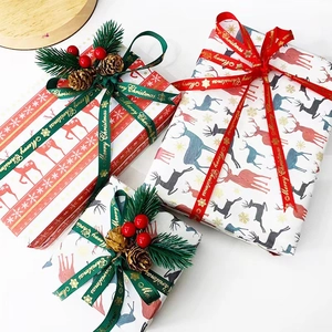 Detail of Christmas gift wrap set with reindeer patterns, pine cones and red berries