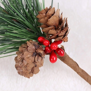 Miniature Christmas pine branch with red berries and natural pine cones for holiday decor