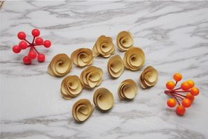 Flat lay of 11 handmade natural wood shavings roses with rustic burnt edges on marble surface