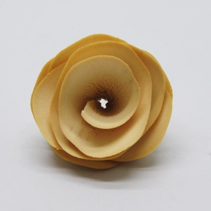 Close-up of spiral wooden flower in warm orange for DIY Christmas wreath and craft projects