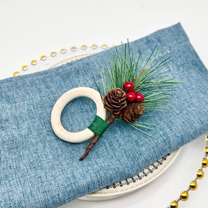 Christmas napkin ring with pine cones and red berries on a wooden circle base