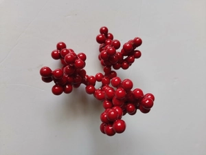 Dettaglio di rami con bacche di Natale rosse lucide in schiuma per decorazioni festive