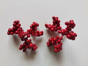 Dettaglio di bacche rosse artificiali con finitura lucida per decorazioni festive
