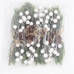 Detail of pine needles, pinecones, and white berries with rustic twine in clear packaging