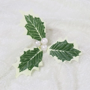 Artificial Christmas holly leaves with white berries for holiday tree and gift decoration