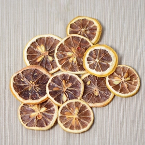 Dried natural lemon slices for candles and crafts on textured light gray background
