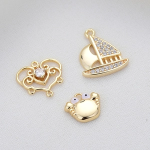 Golden heart, sailboat, and crab pendants set with sparkling zircon for DIY jewelry