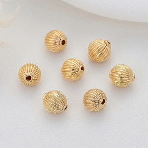 Macro shot of 14k gold-filled hollow striped beads for DIY jewelry making and craft projects