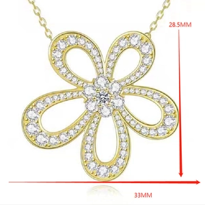 Dettaglio macro di un ciondolo a fiore a cinque petali placcato in oro 14K con zirconi