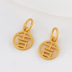 Gros plan sur deux pendentifs dorés 14K avec le caractère porte-bonheur Ji évidé