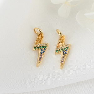 Detailed macro view of 14K gold lightning bolt pendants with colorful zircon inlay