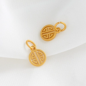 Détail macro de pendentifs évidés plaqués or aux motifs traditionnels pour bijoux DIY