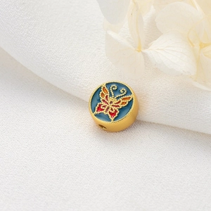 Golden butterfly charm bead with blue enamel and intricate beaded edge for jewelry making
