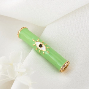 Detail view of light green evil eye cylinder bead with gold plating and zircon inlay