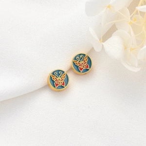 Gold-plated enamel round bead with colorful butterfly pattern on a textured background