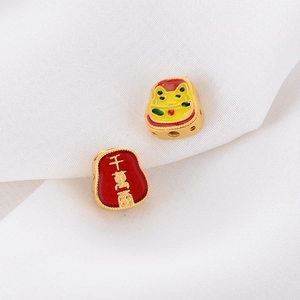 Detailed macro view of golden lucky cat bead and red enamel bead with wealth character