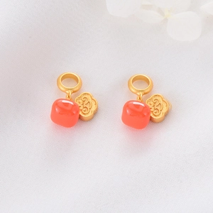 Macro detail of red agate beads and golden Ruyi cloud pendants with a matte sand gold finish