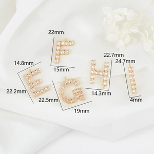 Macro-opname van 14K vergulde zirkonia letters E-I voor het maken van DIY-sieraden