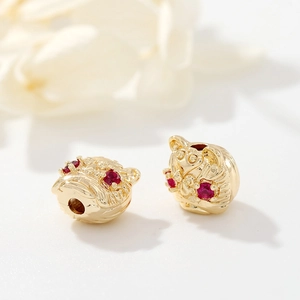 Macro shot of 925 silver golden tiger head bead with red eyes for DIY jewelry making